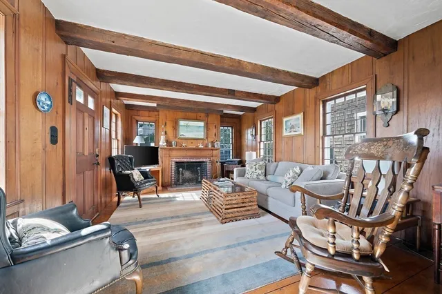 a living room with furniture a fireplace and large windows