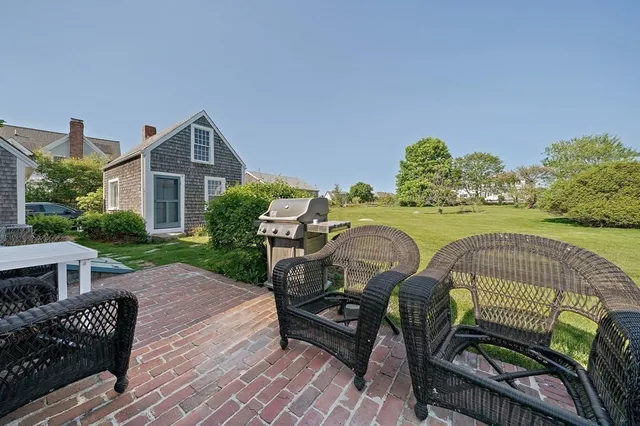 a view of a patio with table and chairs with wooden floor and fence
