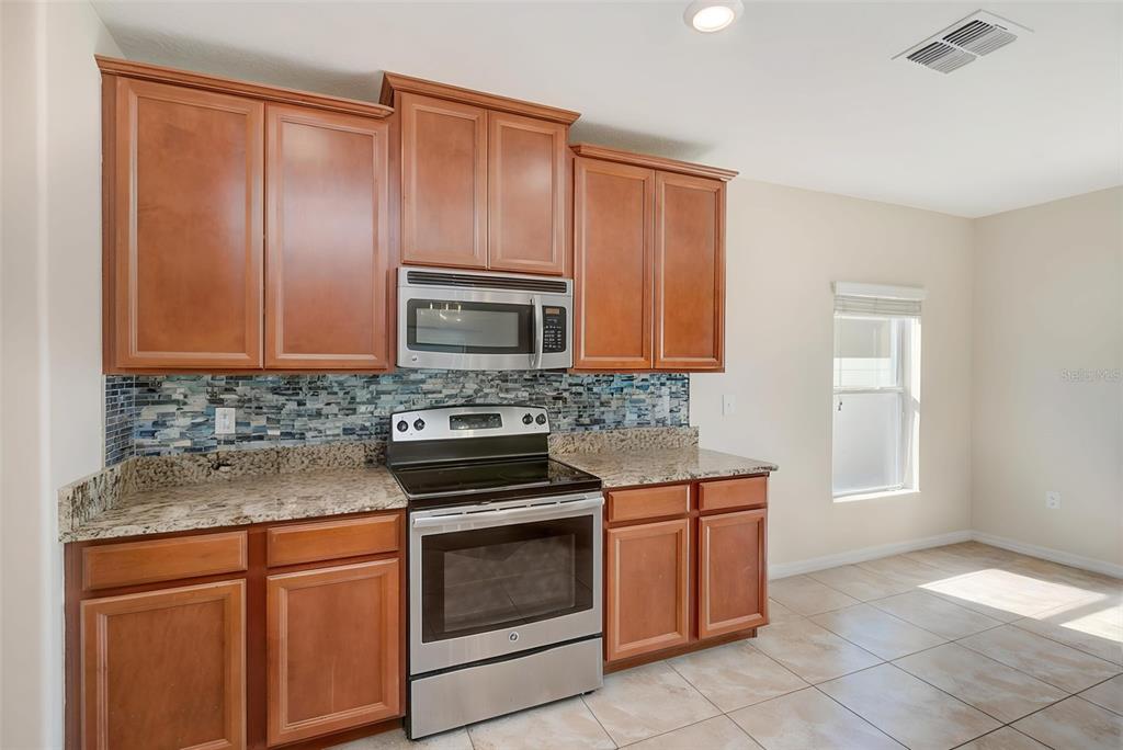 1902 Hawks View Drive Ruskin, FL 33570 - Photo 10 of 41 a kitchen with stainless steel appliances granite countertop a stove a microwave and a sink