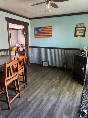 102 South Main Street Paris, ID 83261 - Photo 8 of 33 Dining room with a textured ceiling, wainscoting, dark wood-style flooring, a ceiling fan, and ornamental molding
