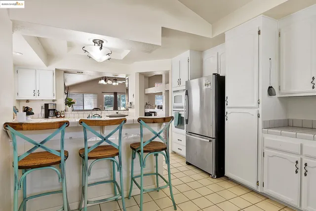 a kitchen with stainless steel appliances granite countertop a refrigerator and a stove top oven