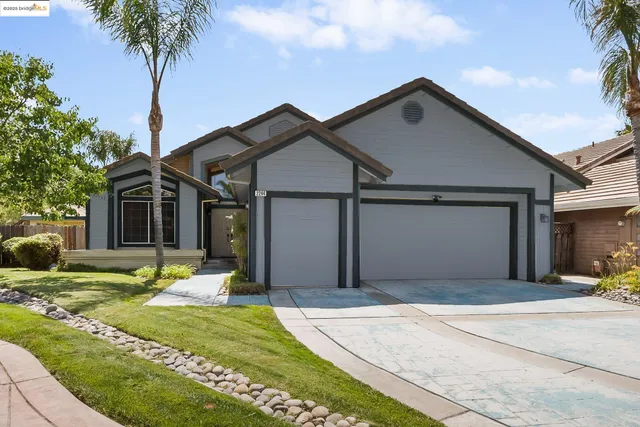 a front view of a house with garden and trees