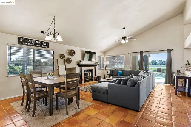 a living room with furniture a dining table and a floor to ceiling window
