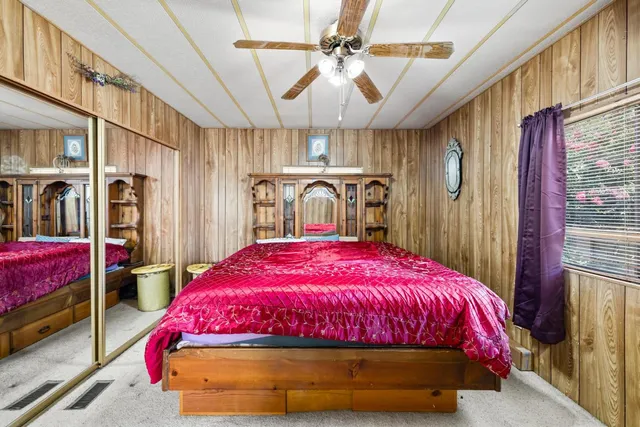 a bedroom with a bed a chandelier and dresser