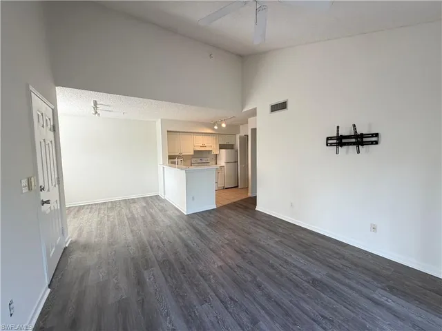 a view of a kitchen with a white cabinets and wooden floor