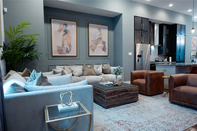 a living room with furniture potted plant and kitchen view