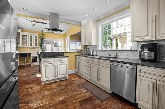 a kitchen with granite countertop a stove sink and cabinets