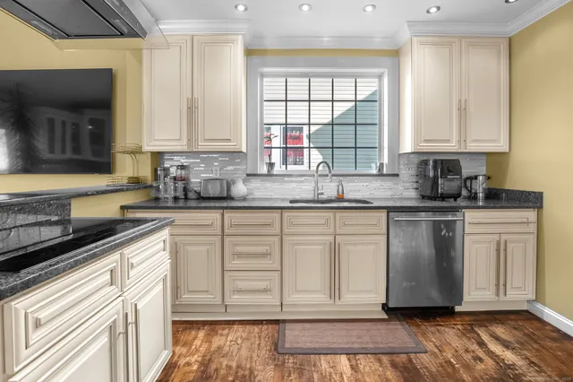a kitchen with stainless steel appliances granite countertop a sink stove and cabinets