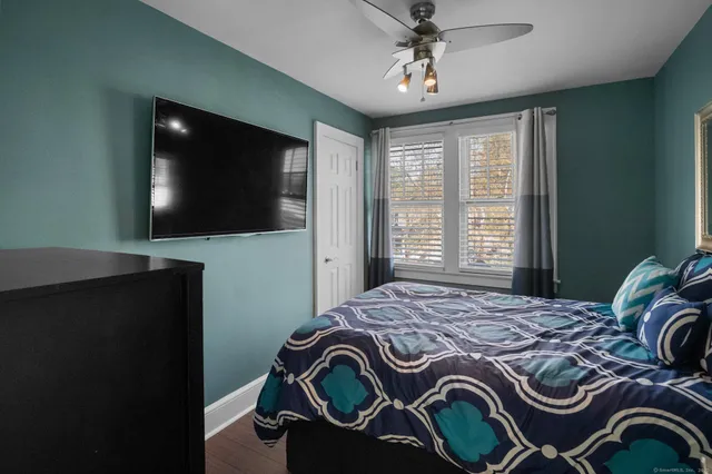 a large bed sitting in a bedroom next to a window and a chandelier