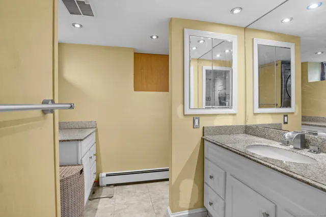 a bathroom with a granite countertop sink and a mirror