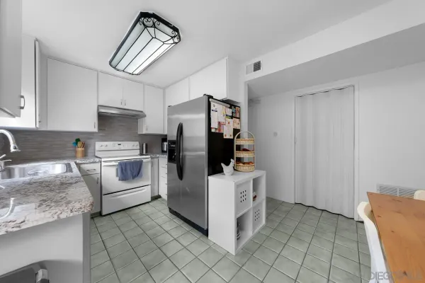 a kitchen with white cabinets and white appliances