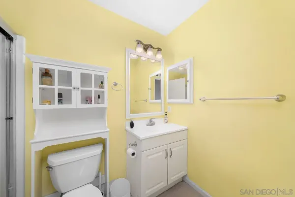 a bathroom with a sink mirror vanity and toilet