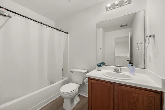 an empty room with a chandelier fan and windows