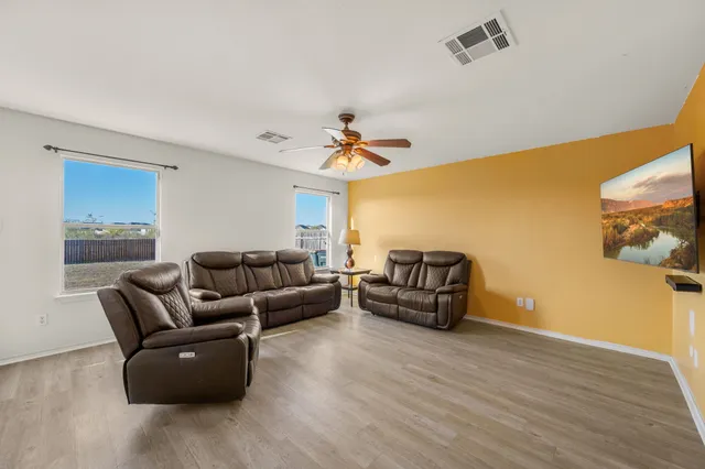 a living room with furniture and kitchen view