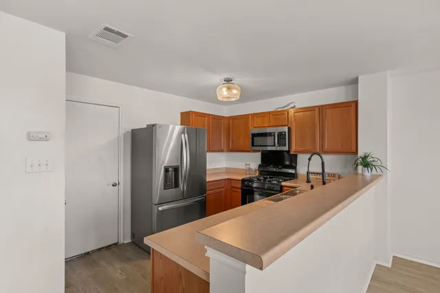 a kitchen with stainless steel appliances granite countertop a refrigerator and a sink
