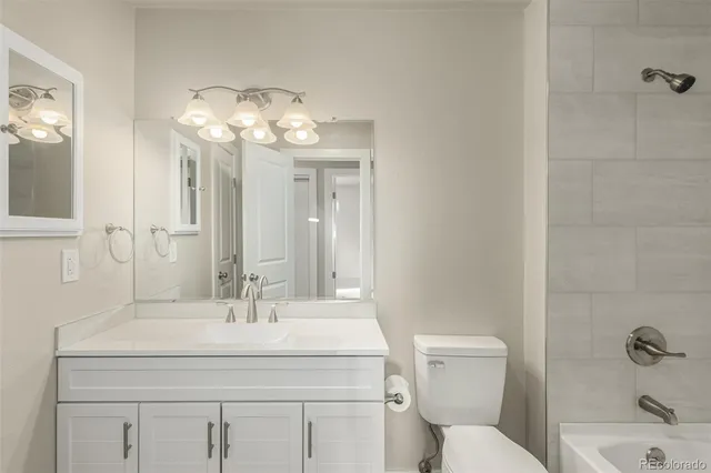 a bathroom with a granite countertop sink a toilet and a mirror