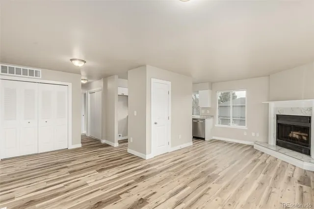 a view of a livingroom with wooden floor and a fireplace