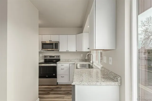 a kitchen with stainless steel appliances granite countertop a sink stove and microwave