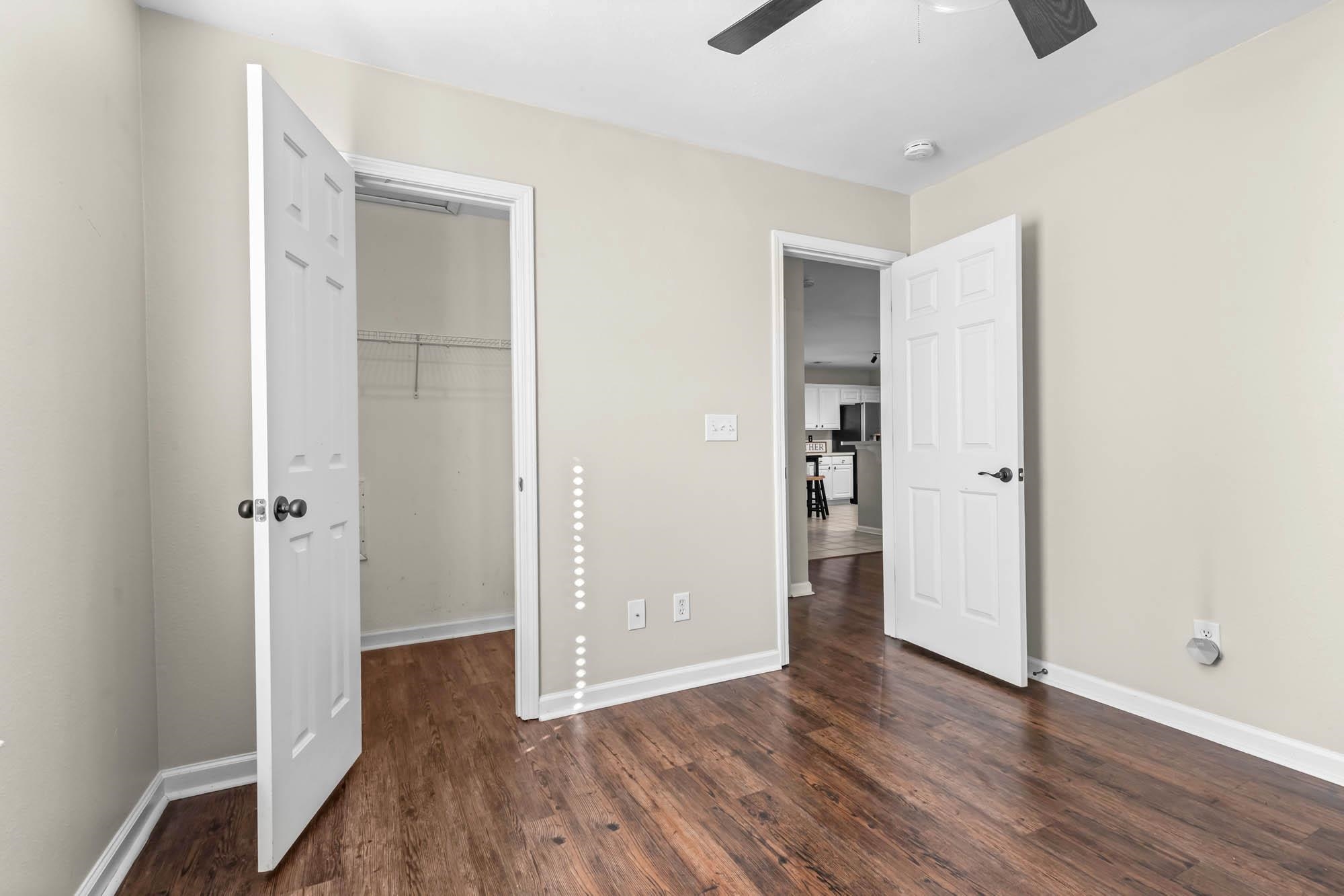 248 McKendree Lane Myrtle Beach, SC 29579 - Photo 14 of 34 Unfurnished bedroom with a walk in closet, dark wood finished floors, and a ceiling fan