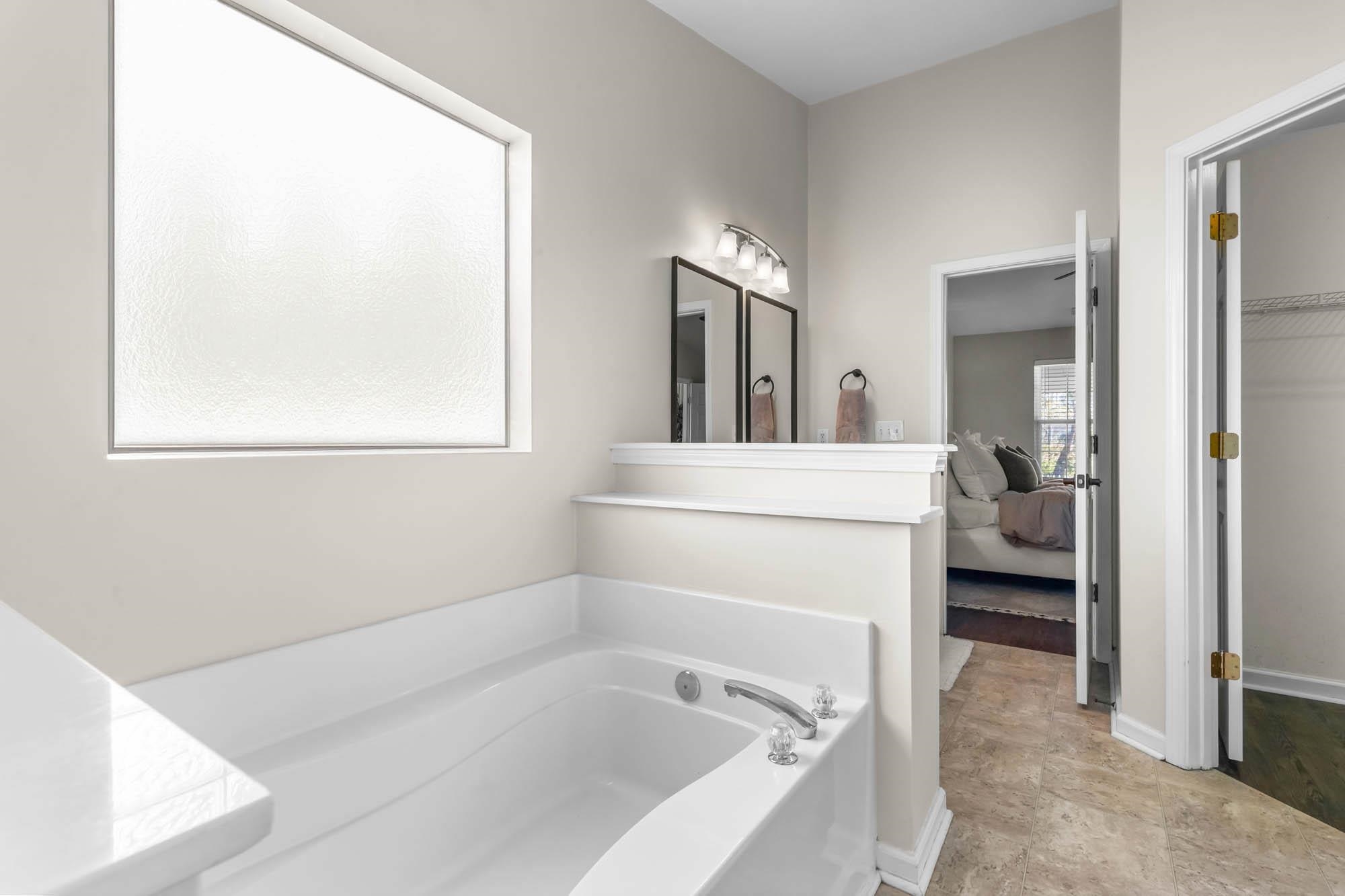 248 McKendree Lane Myrtle Beach, SC 29579 - Photo 32 of 34 Bathroom featuring a bath, ensuite bathroom, vanity, stone finish floors, and a walk in closet