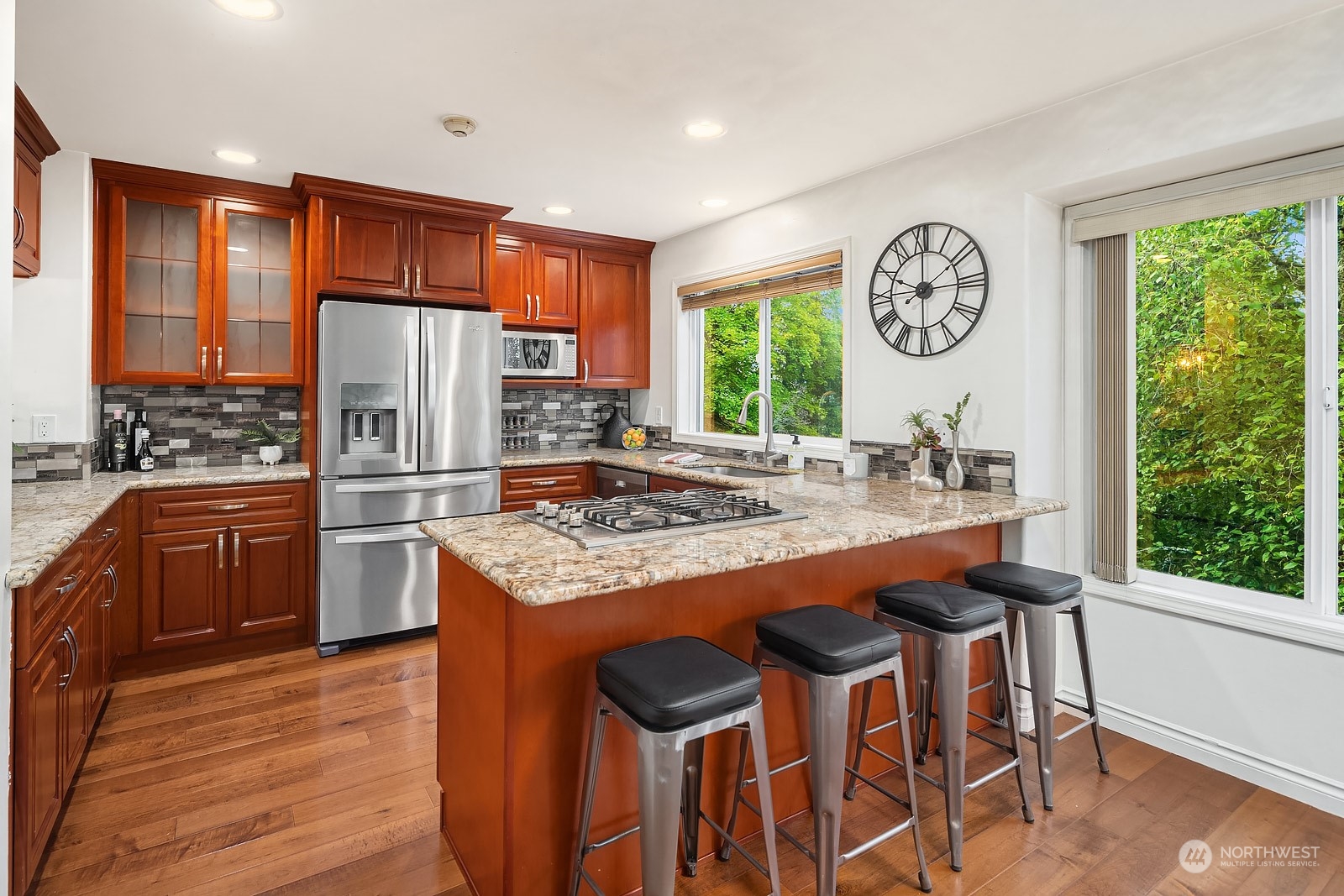 7323 Old Redmond Road, Unit 16 Redmond, WA 98052 - Photo 9 of 26 a kitchen with granite countertop a refrigerator a stove a sink dishwasher a dining table and chairs with wooden floor