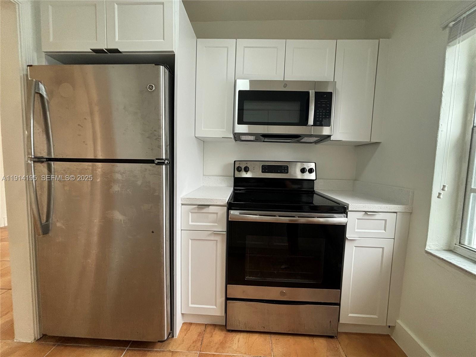 111 Southwest 31st Court, Unit 2 Miami, FL 33135 - Photo 11 of 11 a white refrigerator freezer and a stove sitting inside of a kitchen