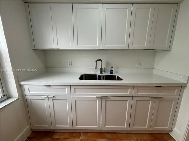 a kitchen with white cabinets and white appliances