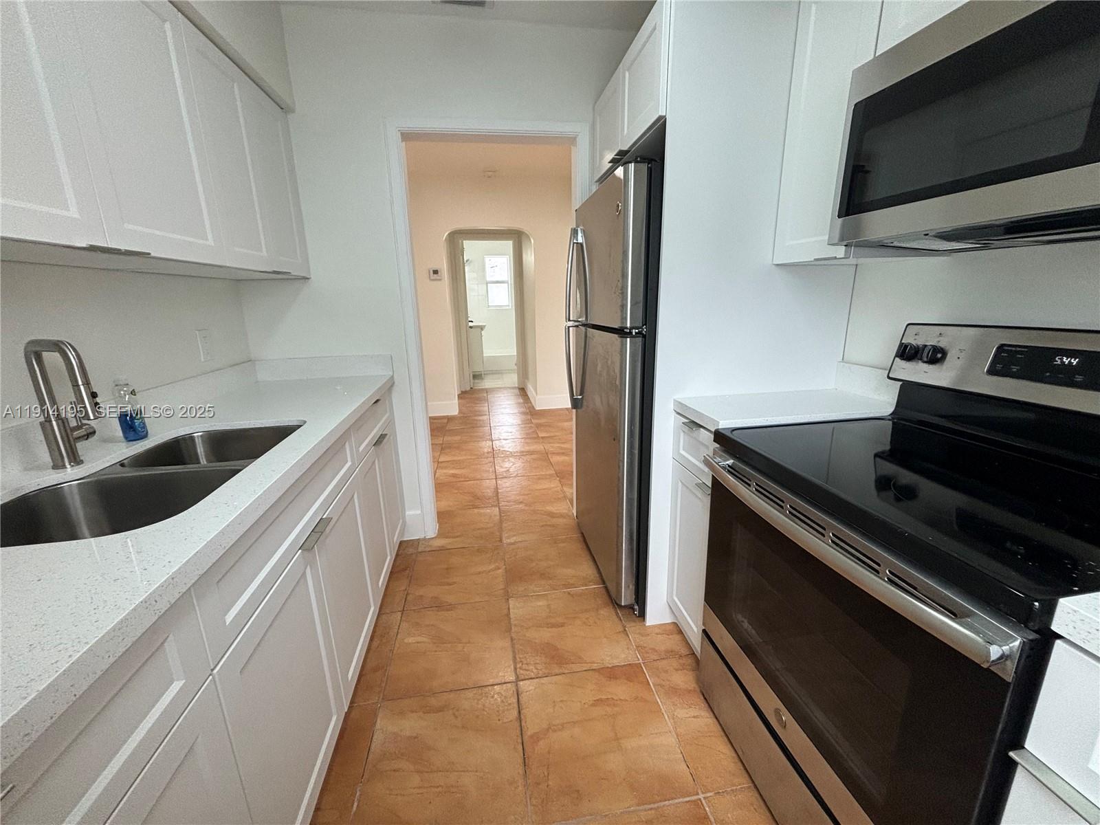 111 Southwest 31st Court, Unit 2 Miami, FL 33135 - Photo 10 of 11 a kitchen with stainless steel appliances granite countertop a refrigerator and a sink