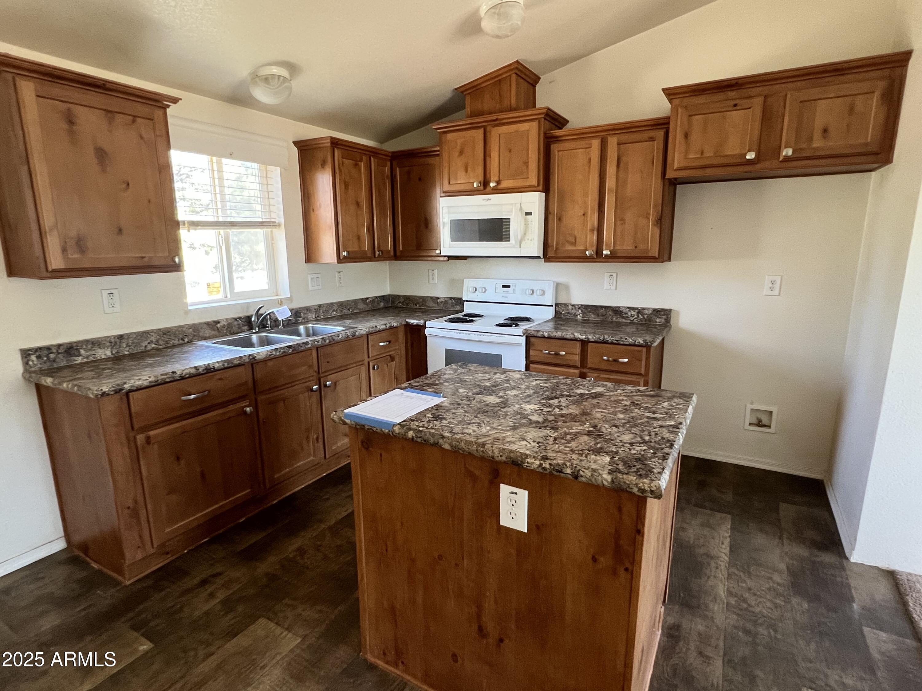 2122 Meadow Lane Overgaard, AZ 85933 - Photo 5 of 19 a kitchen with stainless steel appliances granite countertop a stove a sink dishwasher a microwave oven and a dining table with wooden floor