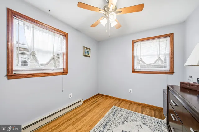 a view of a bedroom with wooden floor and a window