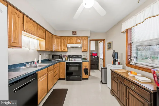 a kitchen with stainless steel appliances sink stove and cabinets