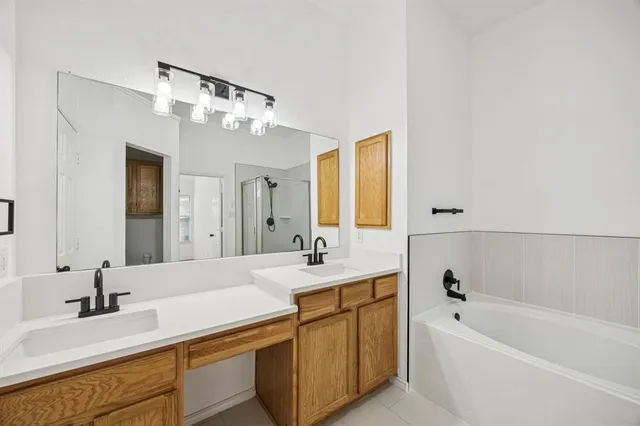 a bathroom with a tub a sink and mirror