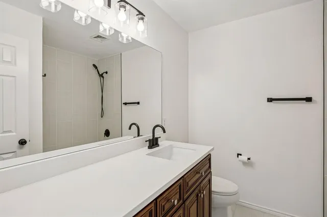 a bathroom with a sink a toilet and shower