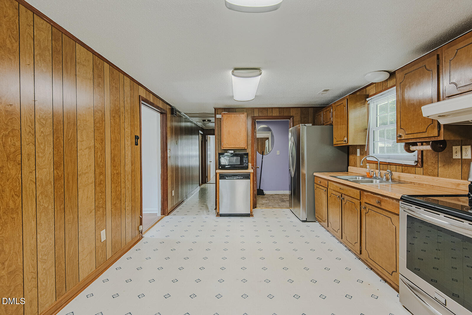1302 Blacksmith Road Efland, NC 27243 - Photo 7 of 46 a kitchen with stainless steel appliances granite countertop a refrigerator and wooden cabinets