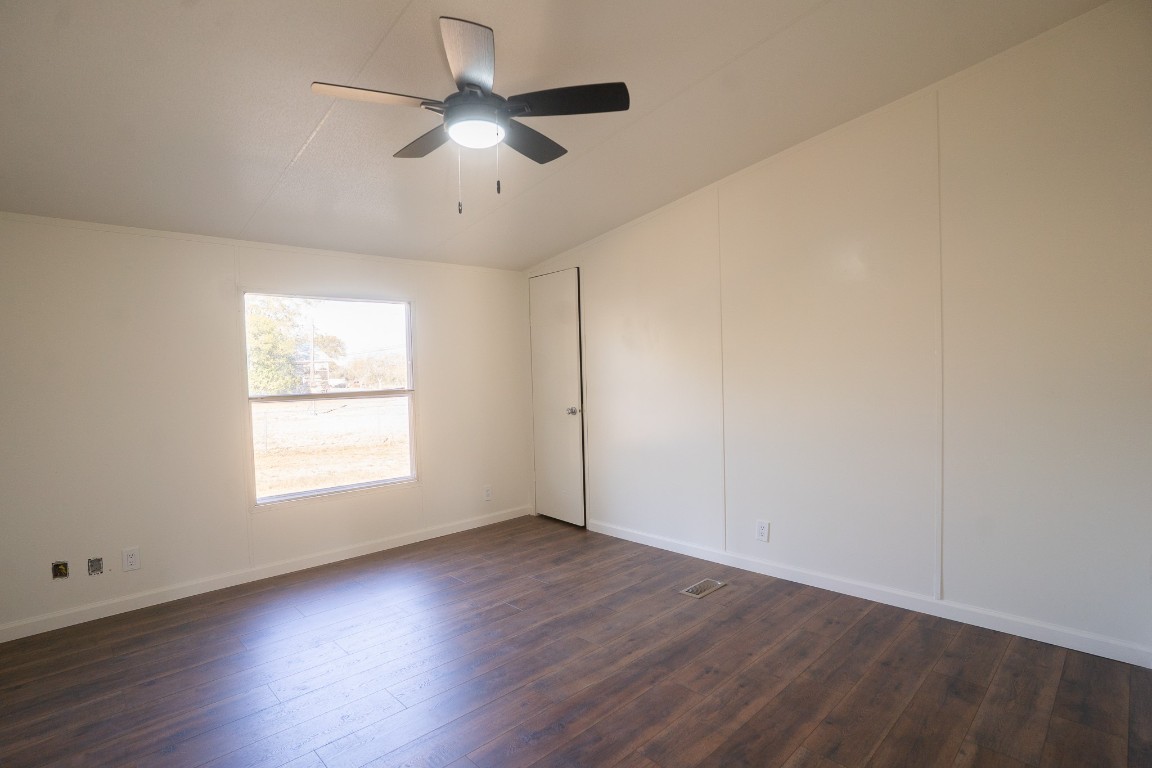404 South Mill Street Flatonia, TX 78941 - Photo 17 of 34 an empty room with wooden floor ceiling fan and windows