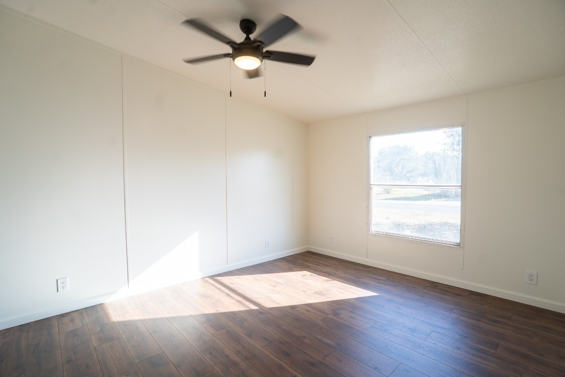 404 South Mill Street Flatonia, TX 78941 - Photo 18 of 34 an empty room with wooden floor ceiling fan and windows
