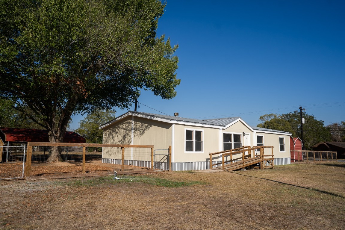 404 South Mill Street Flatonia, TX 78941 - Photo 5 of 34 a view of white house with a large tree and wooden fence