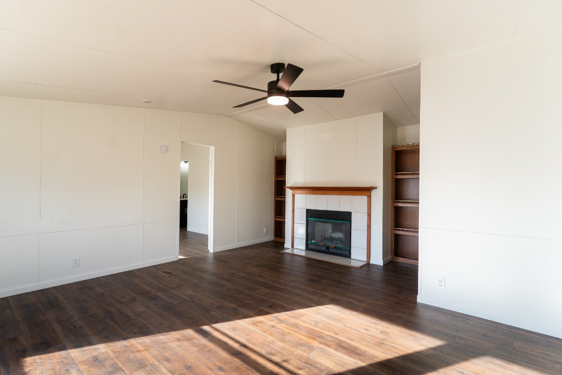 404 South Mill Street Flatonia, TX 78941 - Photo 8 of 34 a view of a livingroom with a fireplace a ceiling fan and wooden floor