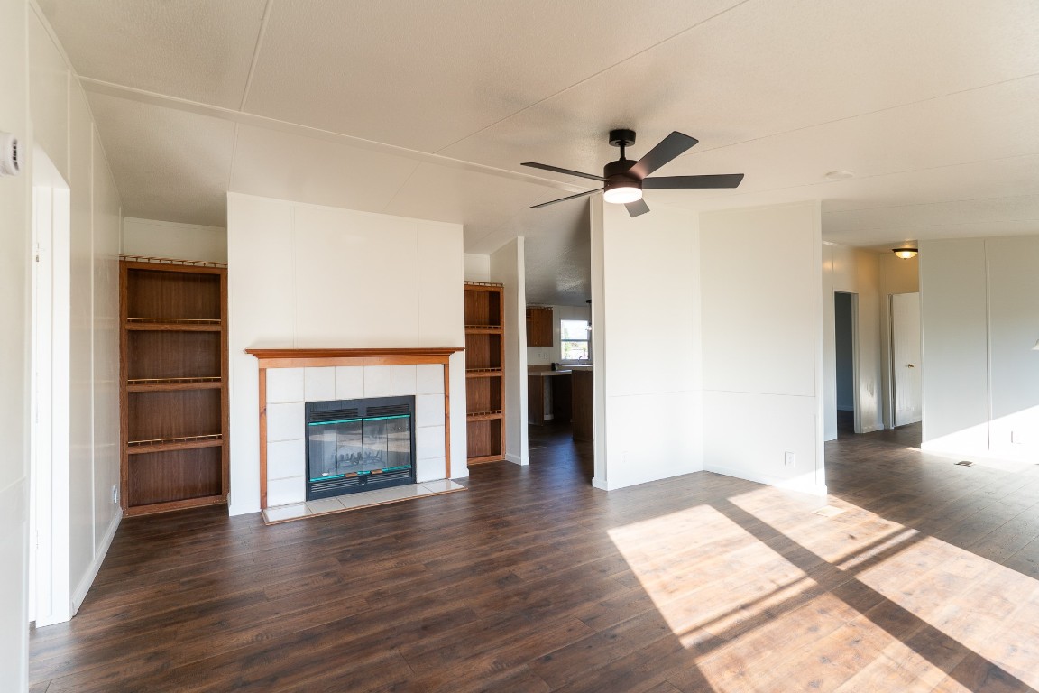 404 South Mill Street Flatonia, TX 78941 - Photo 9 of 34 a view of a livingroom with a fireplace a ceiling fan and wooden floor