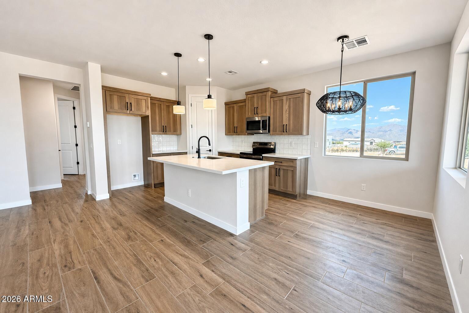 16957 East Bobwhite Way Rio Verde, AZ 85263 - Photo 6 of 25 a kitchen with stainless steel appliances kitchen island wooden floors cabinets and a chandelier