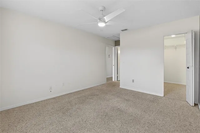 an empty room with a ceiling fan and a window