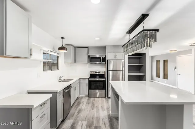 a kitchen with stainless steel appliances kitchen island a cabinets and wooden floor