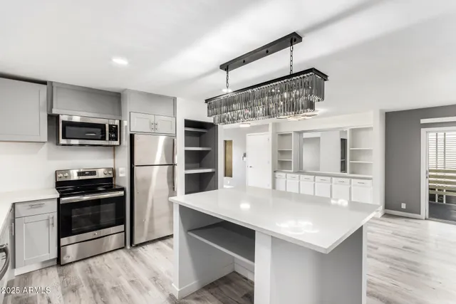 a kitchen with stainless steel appliances kitchen island a refrigerator and a stove top oven
