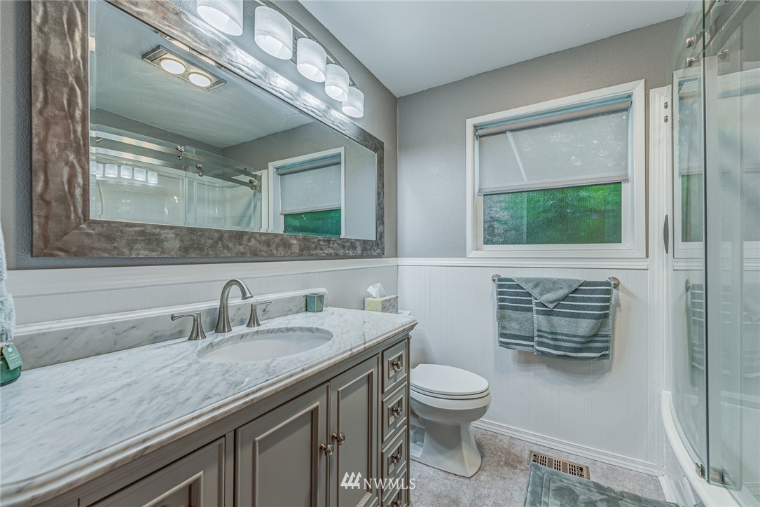 20600 2nd Avenue Southwest Normandy Park, WA 98166 - Photo 13 of 40 a bathroom with a granite countertop sink a toilet and a mirror