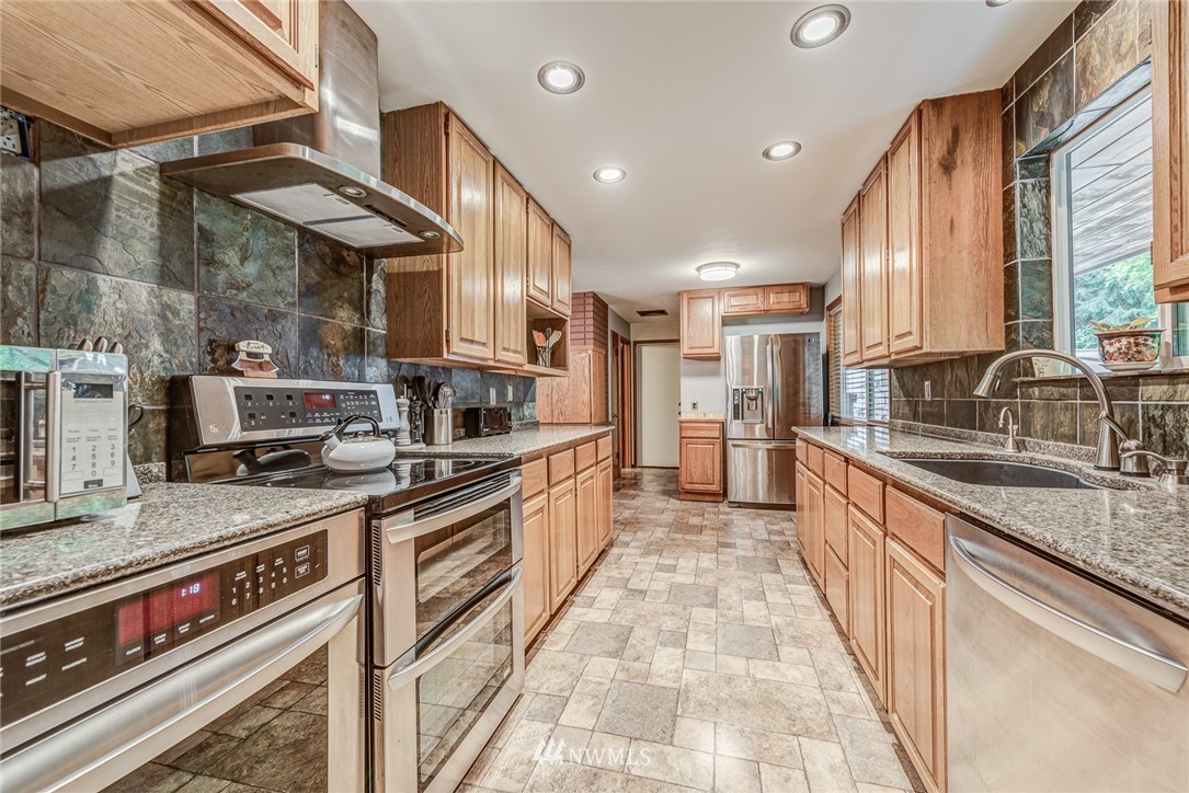 20600 2nd Avenue Southwest Normandy Park, WA 98166 - Photo 23 of 40 a kitchen with stainless steel appliances granite countertop a sink and a stove