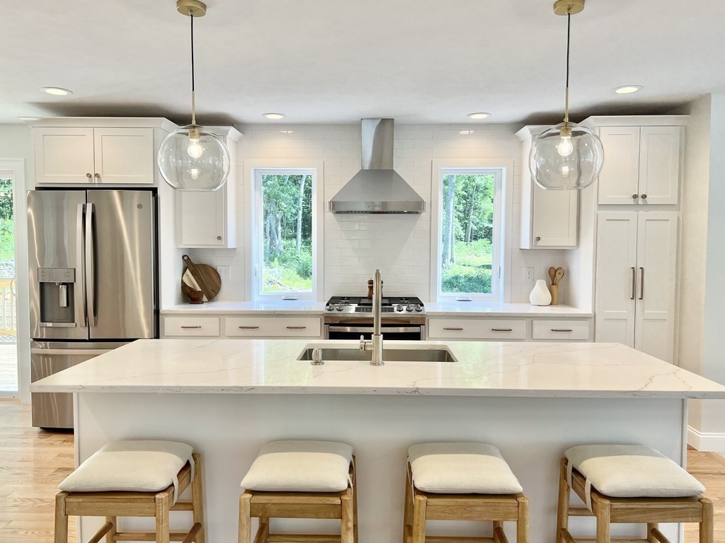7 Sandy Pond Road Ayer, MA 01432 - Photo 5 of 22 a kitchen with stainless steel appliances a table chairs refrigerator and microwave