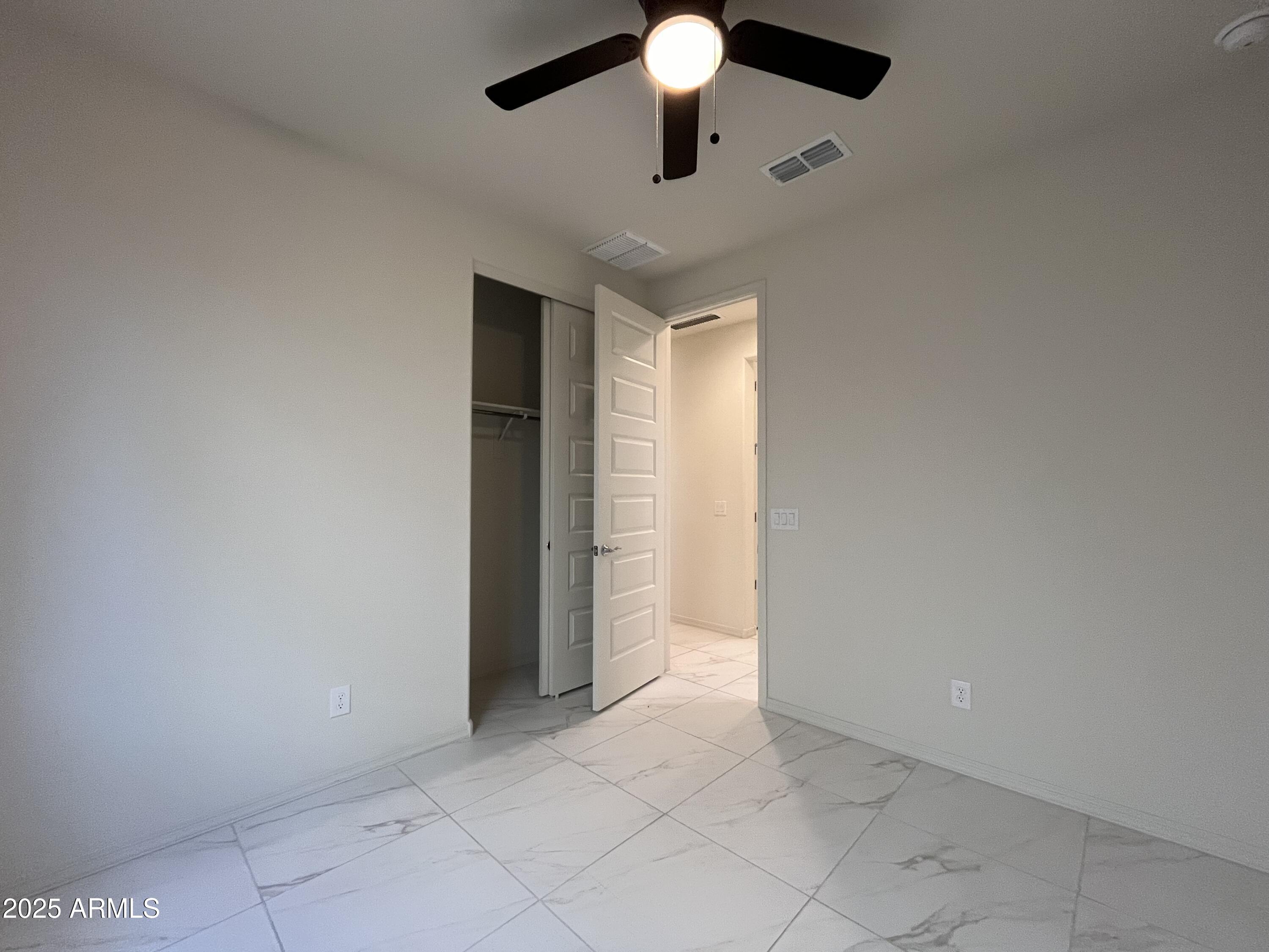 6970 West Gwen Street Laveen, AZ 85339 - Photo 14 of 30 an empty room with closet and chandelier fan