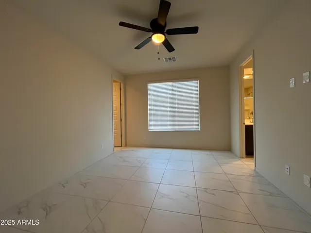 a view of a livingroom with a chandelier fan and kitchen view