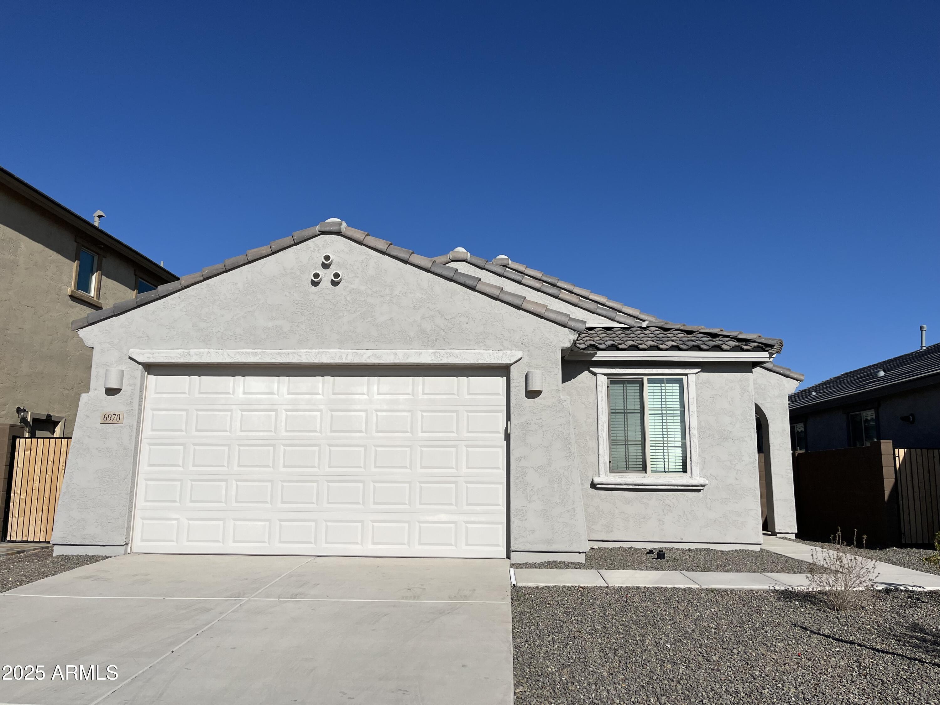 6970 West Gwen Street Laveen, AZ 85339 - Photo 2 of 30 a front view of a house with a garage