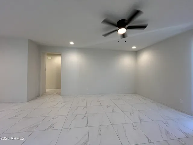 an empty room with fan and windows